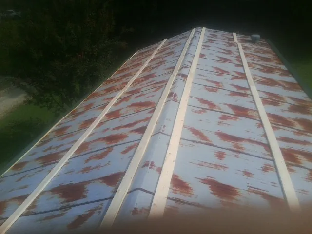 Rusted metal roof panels with new wood purlins before replacement — Storm Damage Roof Repair in Gloverville by Roofing Brothers