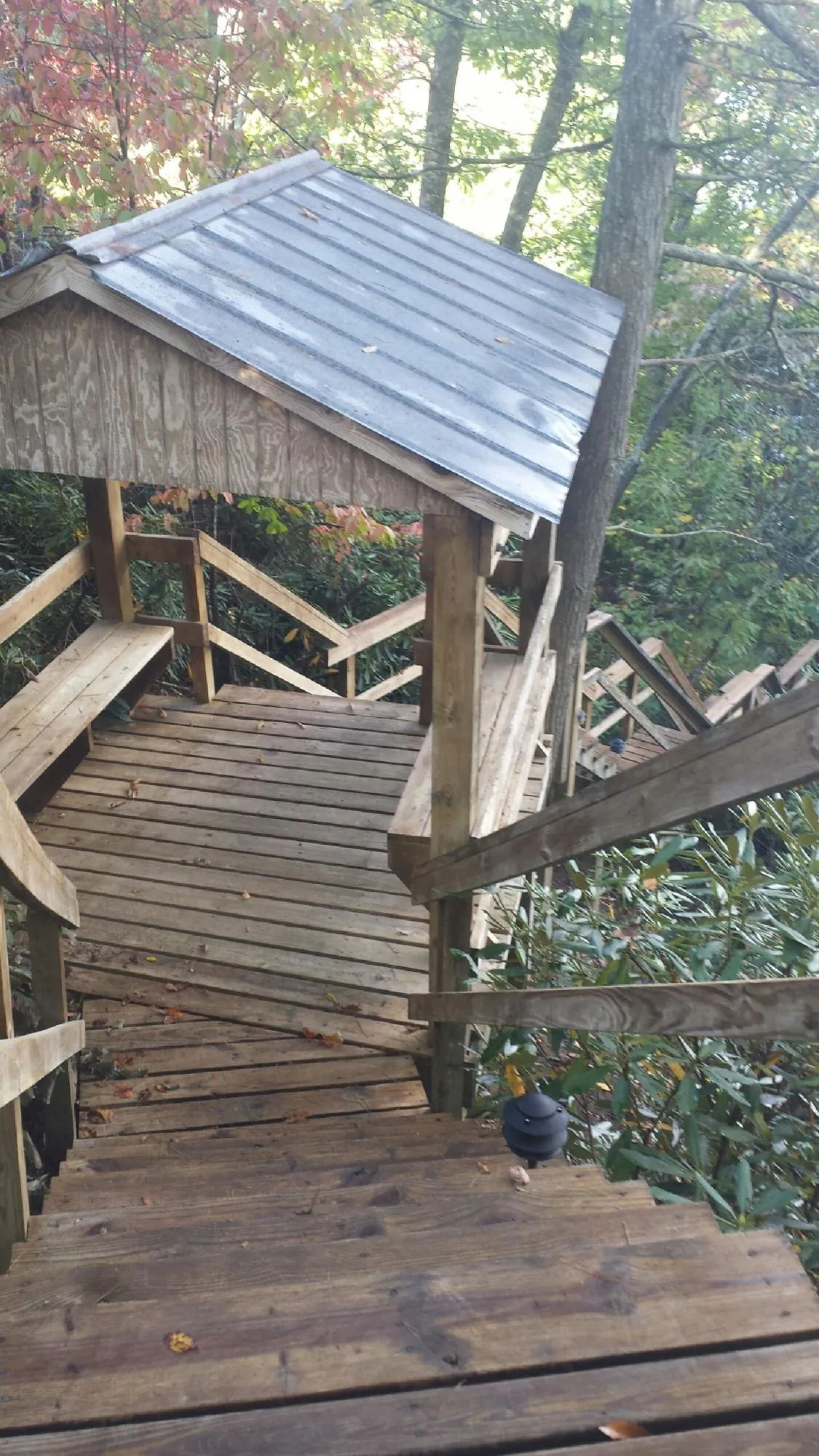 Metal roofed shelter over wooden steps on a wooded walkway — Skylight Repair & Installation work by our crew in Gloverville