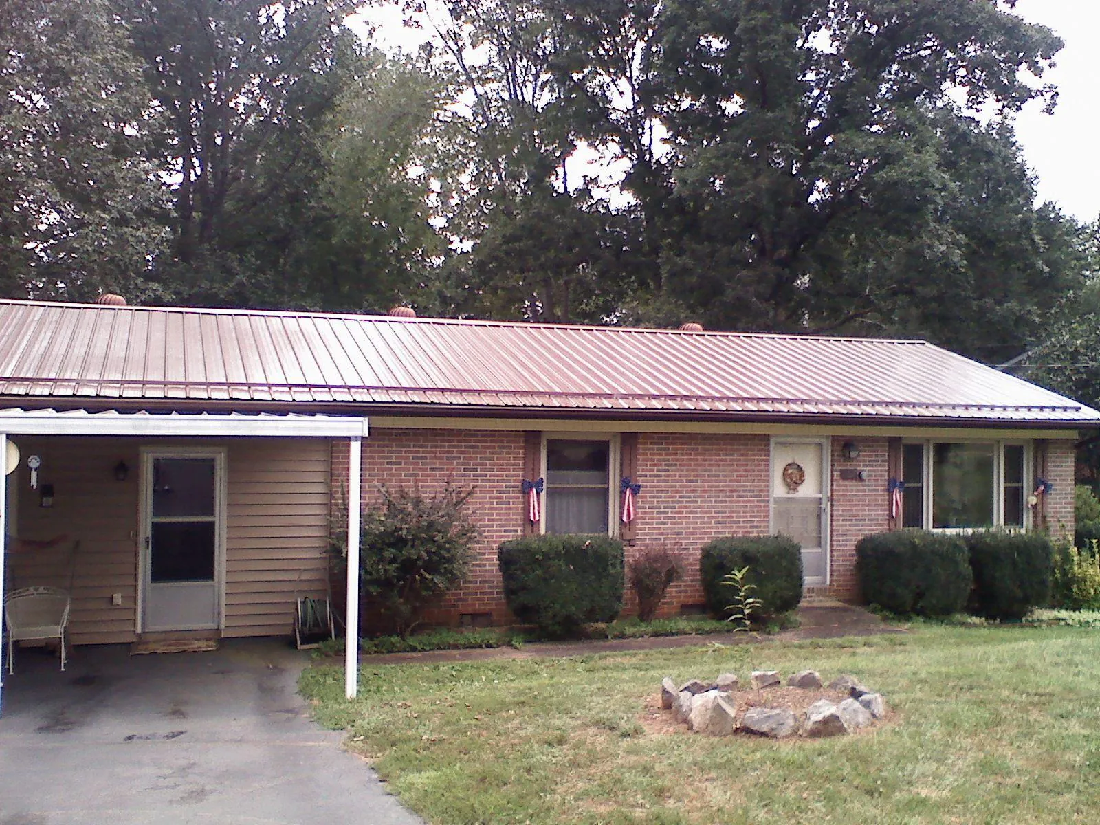 Bronze metal roof and carport on a brick ranch home — Roof Repair work by our crew in Gloverville
